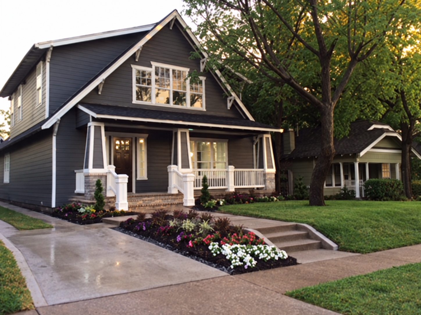 Dark gray Craftsman-style home with white trim and a landscaped front walk