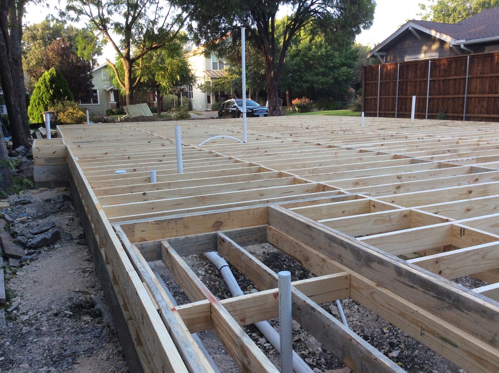 Detailed view of pier-and-beam floor joist framing and plumbing rough-ins